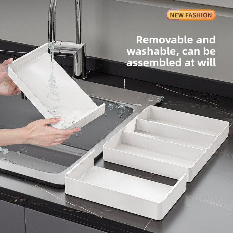 Hand rinsing a removable Nexora Plus organizer compartment under a kitchen faucet